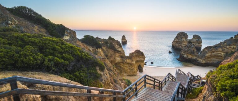 wooden steps through cliffs down to beach at sunset