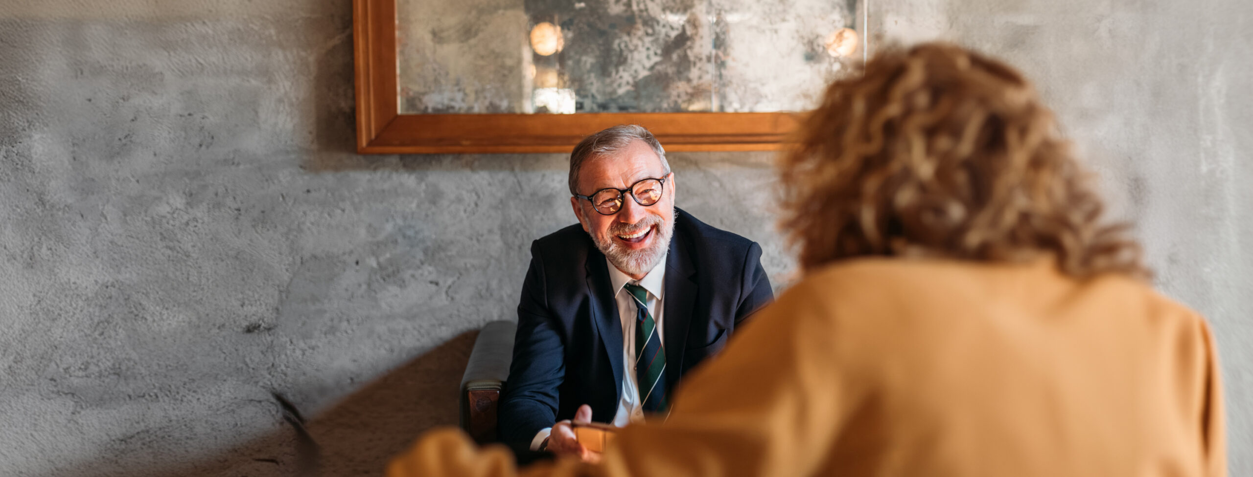 man sitting in a chair smiling at woman